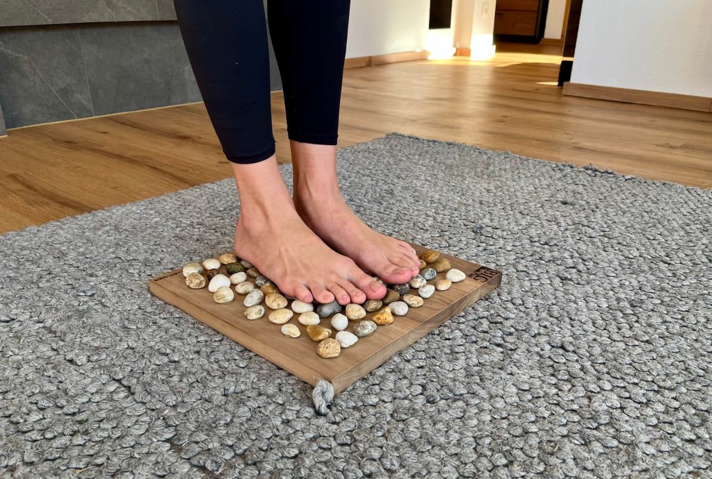 Reflexzonenmassage auf der Fußsohle mit dem Big Foot Vital Board aus Nussholz von Full Balance