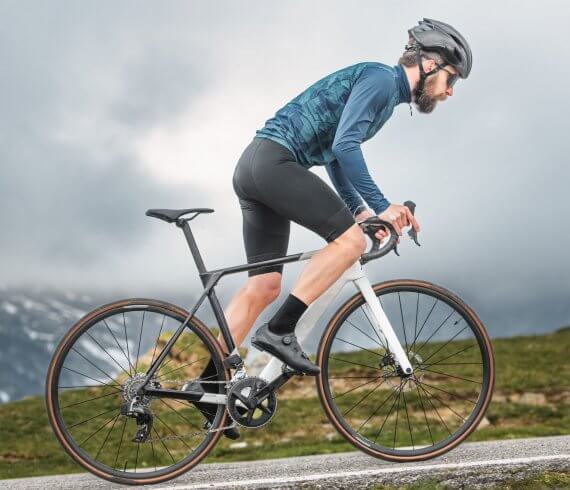 Radfahrer bei Regeneration nach dem Sport mit Fußmassage