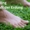 Füße stehen im Gras und nehmen die Energie der Erde auf - Grounding, Erdung