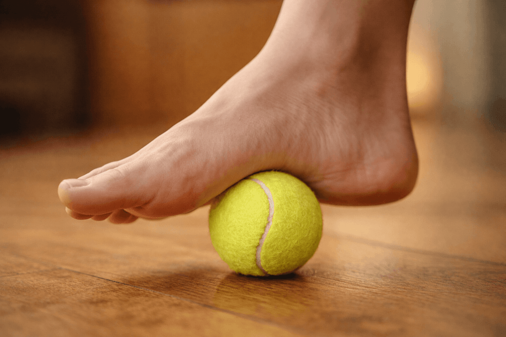 Gezielter Rollmassage-Druck auf der Fußsohle durch Tennisball